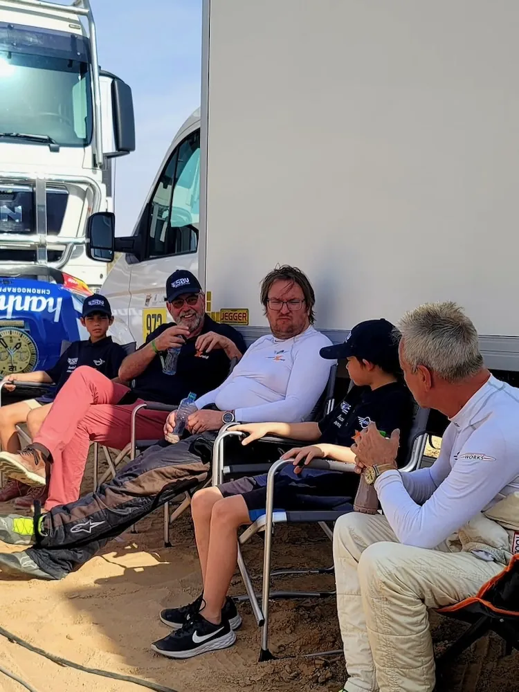 Thierry and the family seated with Stephan in his racing suit beside the MINI and support truck