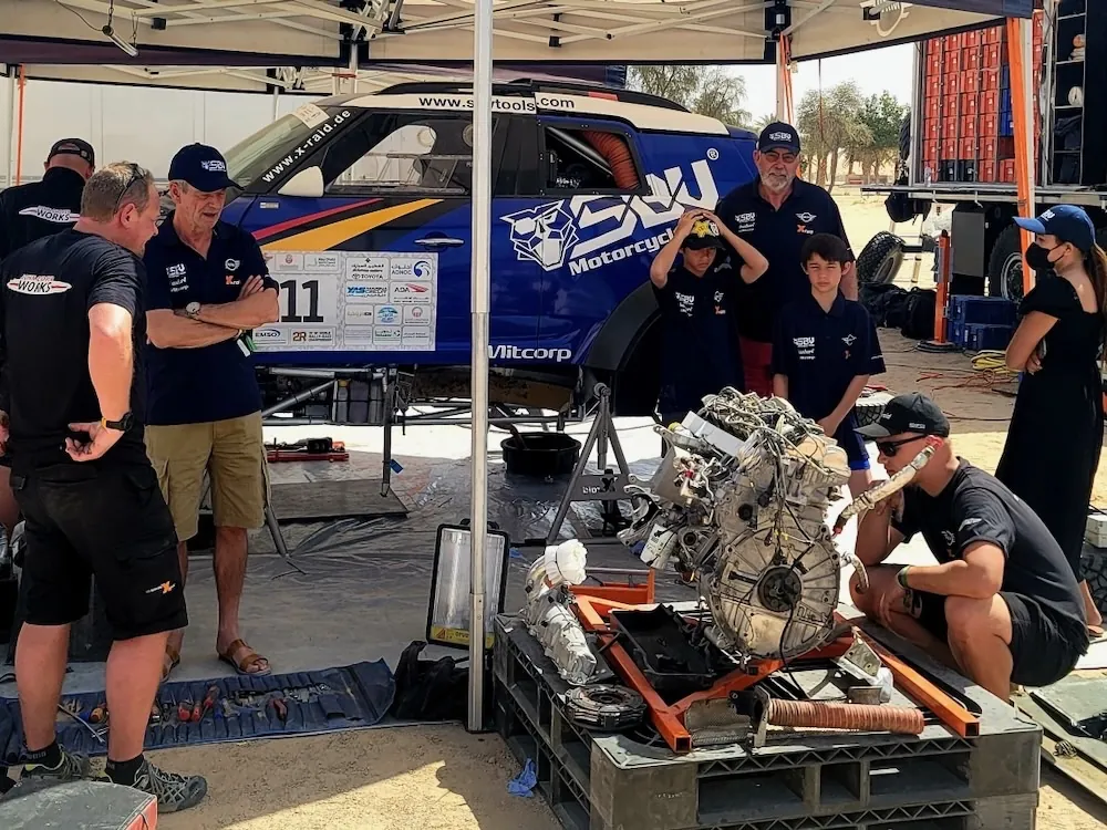 The engine out on a stand while the crew works beside the blue SBVTools MINI and support truck