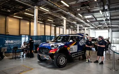 The X-raid team gathered beside the blue SBVTools MINI before the rally