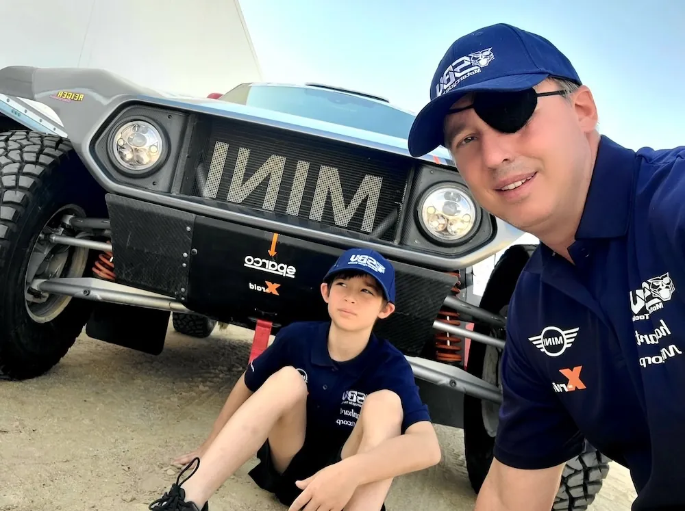 Thierry and his son beside the blue SBVTools MINI at the rally